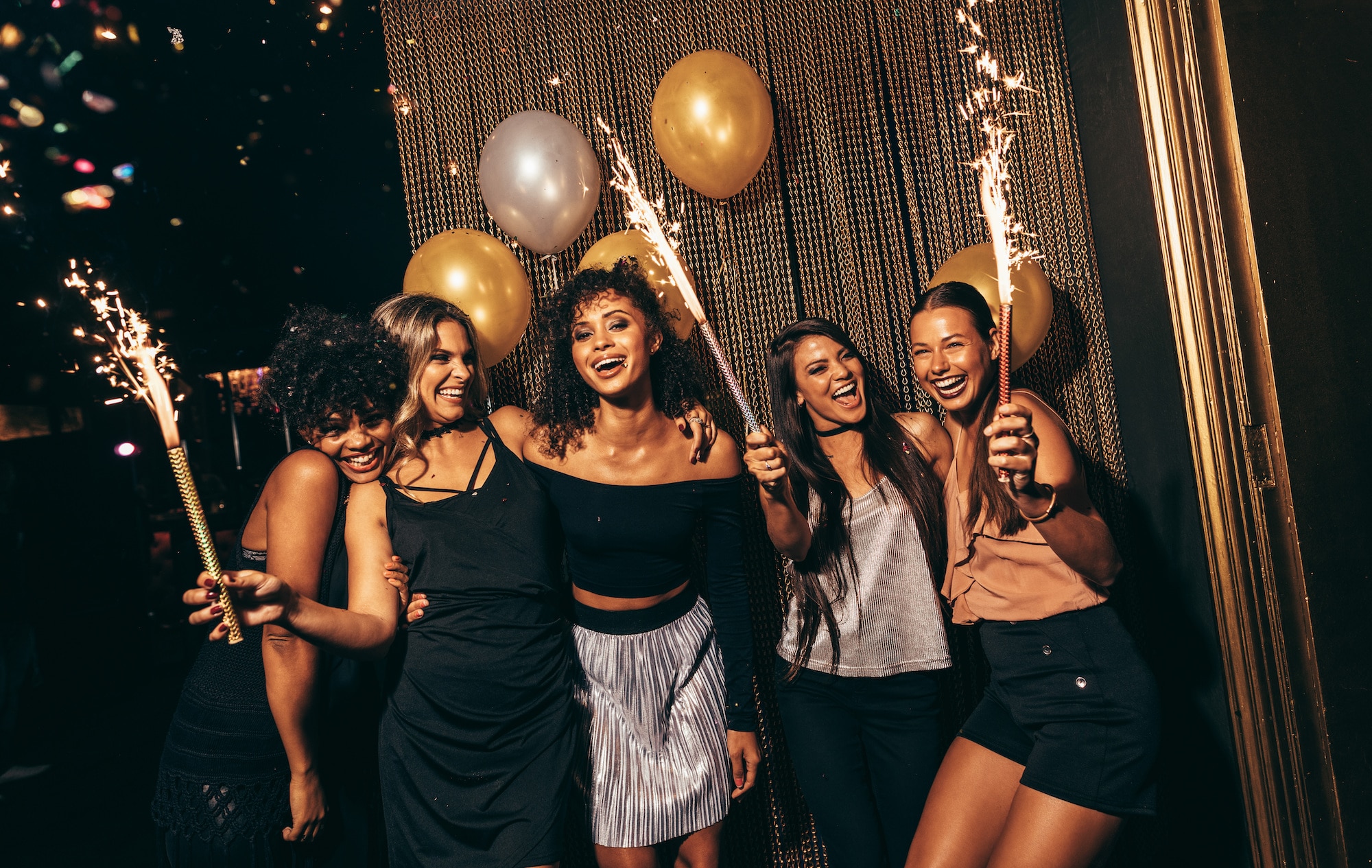 Grupo de mulheres comemorando com fogos de artifício no pub. Amigas curtindo a festa na boate